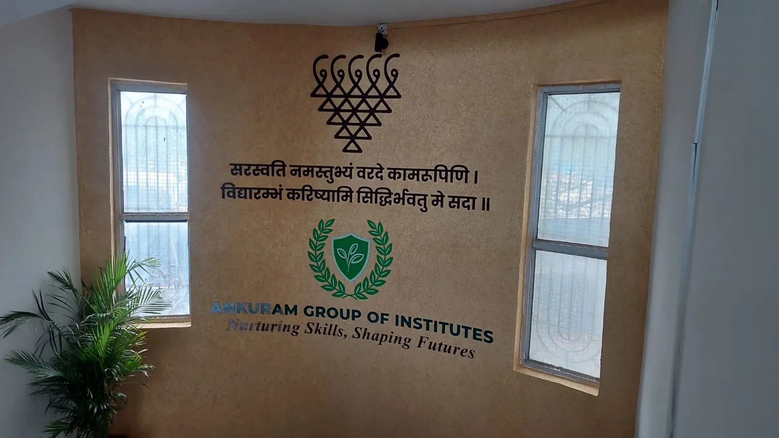 Ankuram Group of Institutes emblem and Sanskrit verse on an interior feature wall